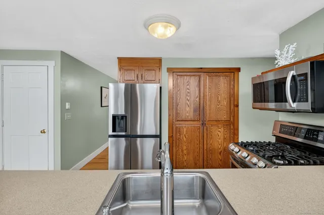 a kitchen with stainless steel appliances a refrigerator and a stove top oven