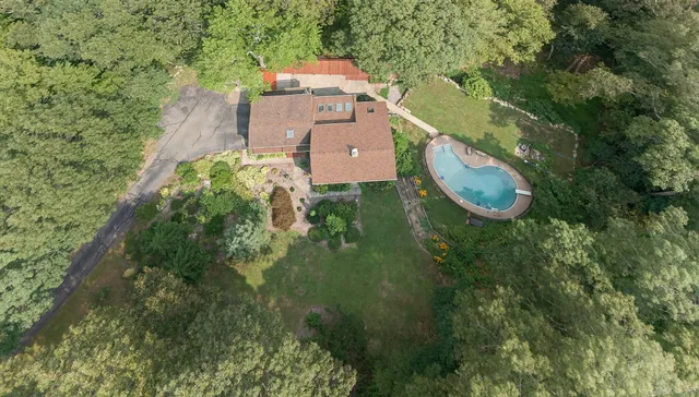 an aerial view of a house with a yard swimming pool and outdoor seating