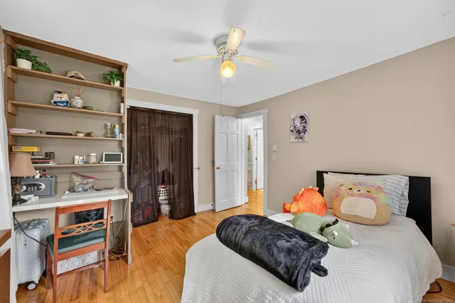 a bedroom with a bed and wooden floor