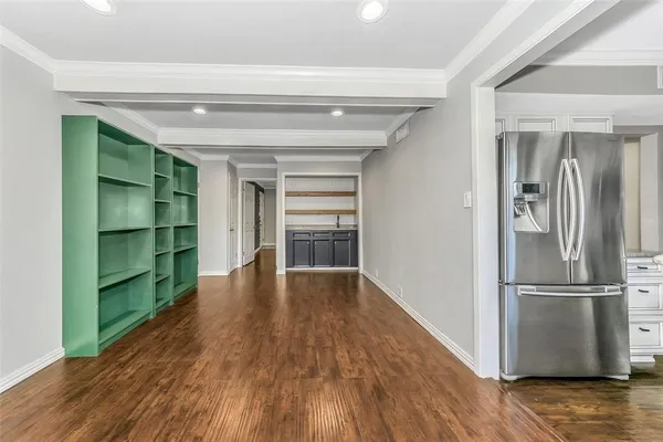 a view of empty room with wooden floor and window