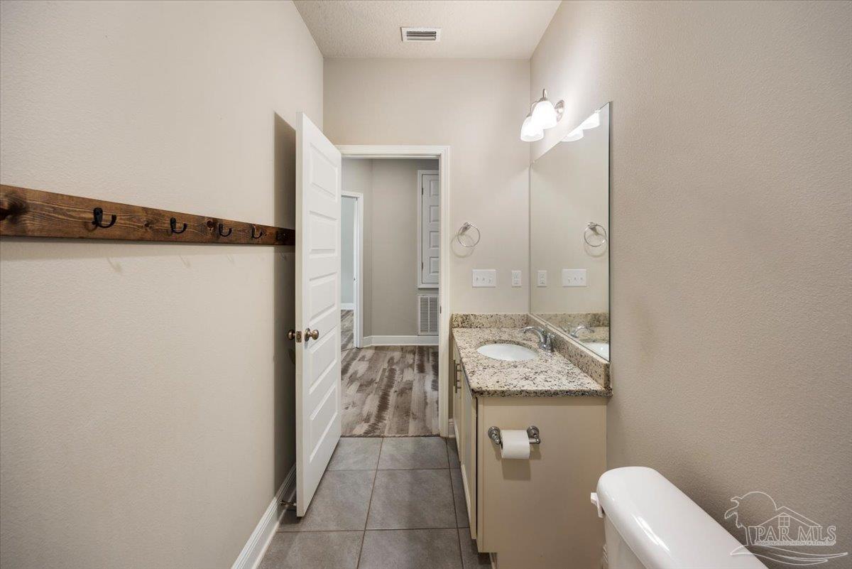 8056 Stream Ridge Road Pensacola, FL 32526 - Photo 30 of 66 a en suite bathroom with a granite countertop sink a toilet and shower