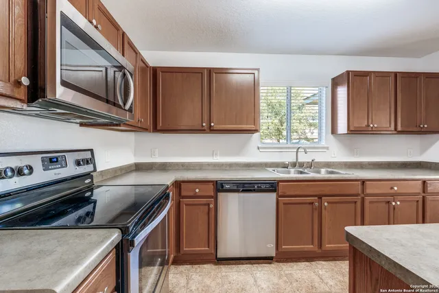 a kitchen with stainless steel appliances granite countertop a sink stove and microwave