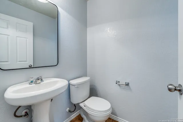 a bathroom with a sink a toilet and mirror