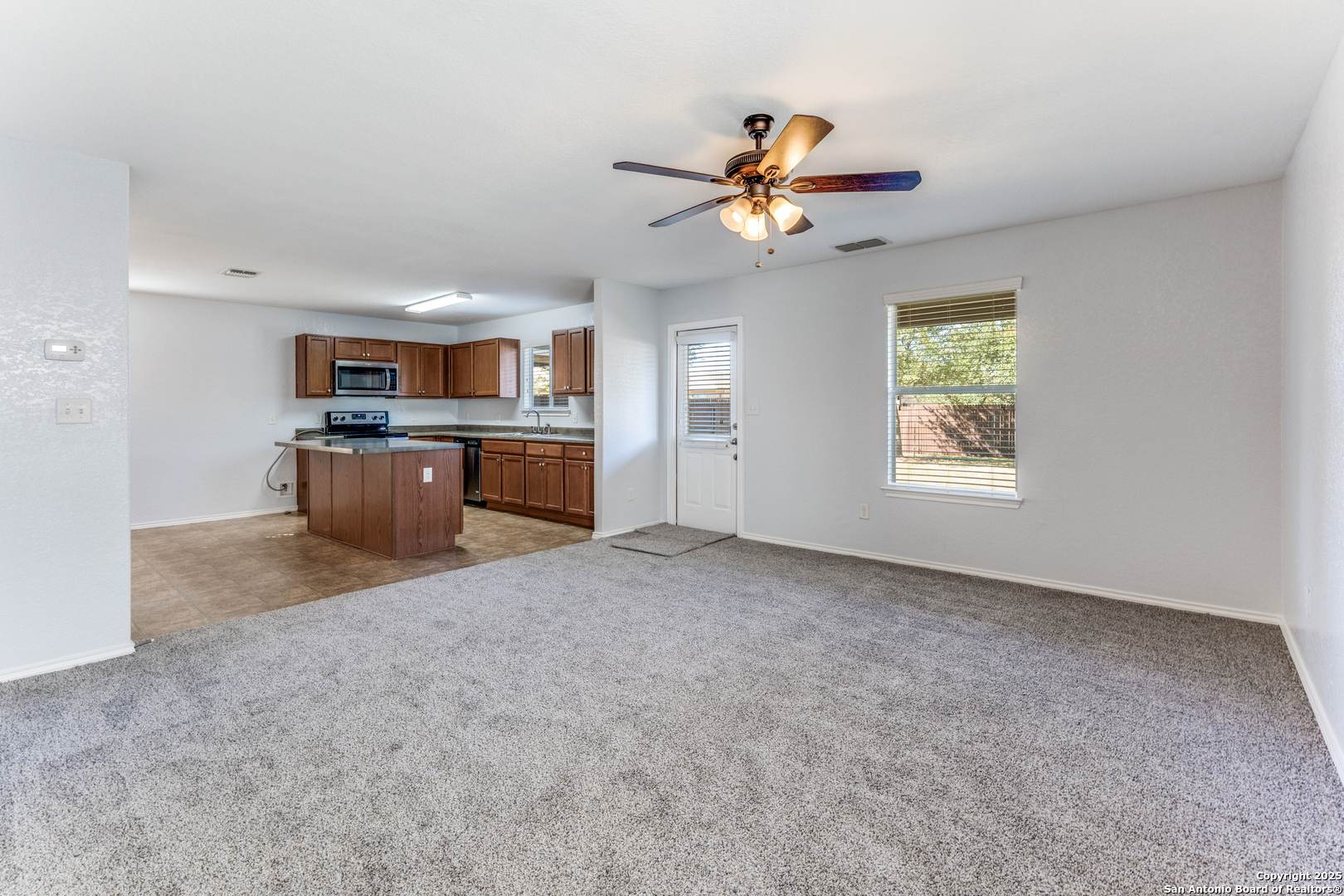 455 Walnut Crest Schertz, TX 78154 - Photo 7 of 30 a view of a kitchen with a stove cabinets a ceiling fan and wooden floor