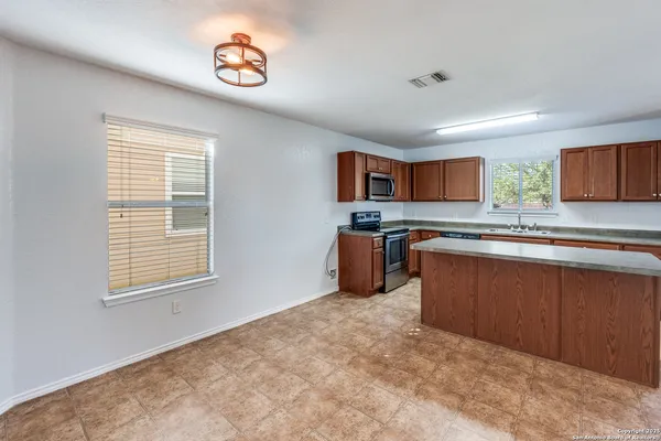 a kitchen with granite countertop a stove top oven a sink dishwasher and a microwave oven on the blue kitchen countertops