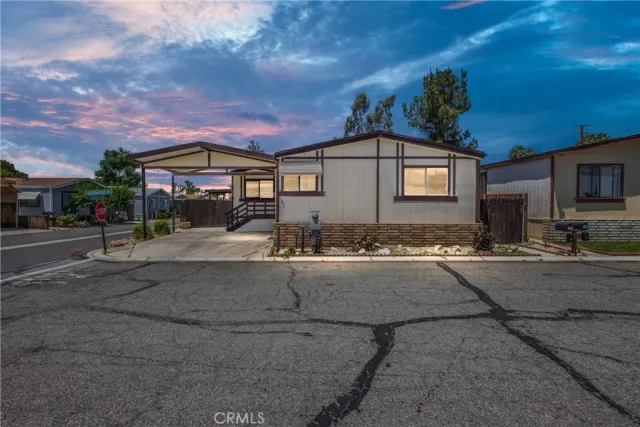 a front view of a house with yard and parking