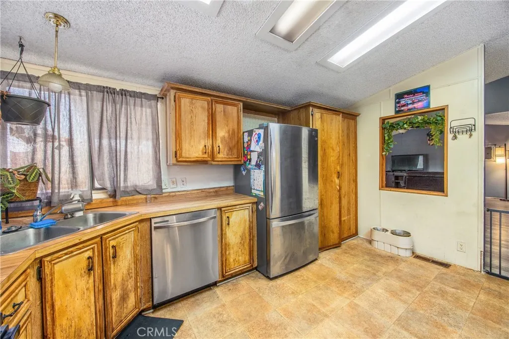 7717 Church Street, Unit 160 Highland, CA 92346 - Photo 15 of 37 a kitchen with stainless steel appliances granite countertop a refrigerator and a sink