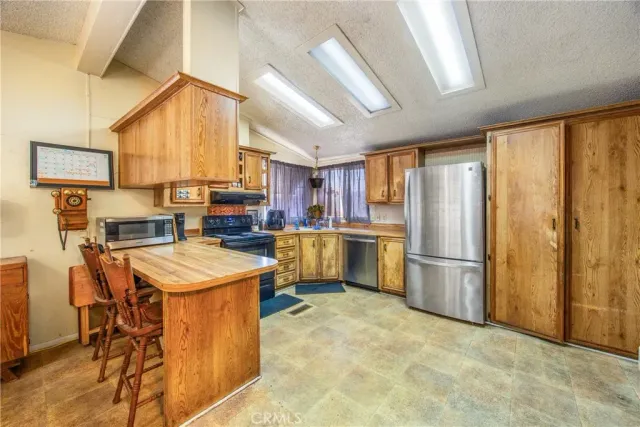 a kitchen with a refrigerator a sink dishwasher with a dining table and chairs