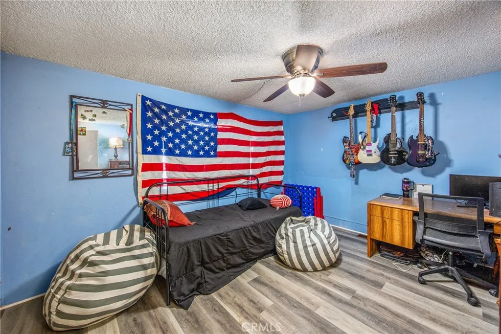 7717 Church Street, Unit 160 Highland, CA 92346 - Photo 20 of 37 a bedroom with bed and a chandelier