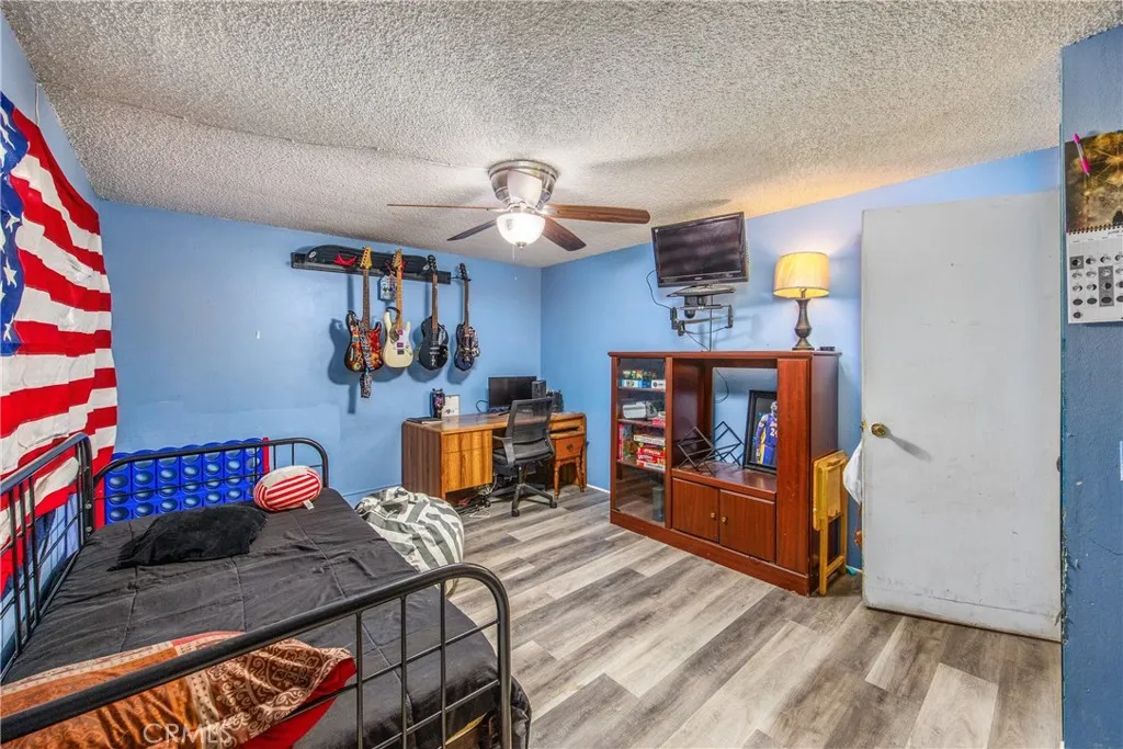 7717 Church Street, Unit 160 Highland, CA 92346 - Photo 21 of 37 a bedroom with furniture and wooden floor