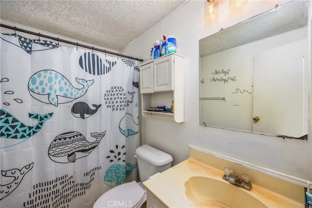 7717 Church Street, Unit 160 Highland, CA 92346 - Photo 22 of 37 a bathroom with a sink mirror vanity and toilet