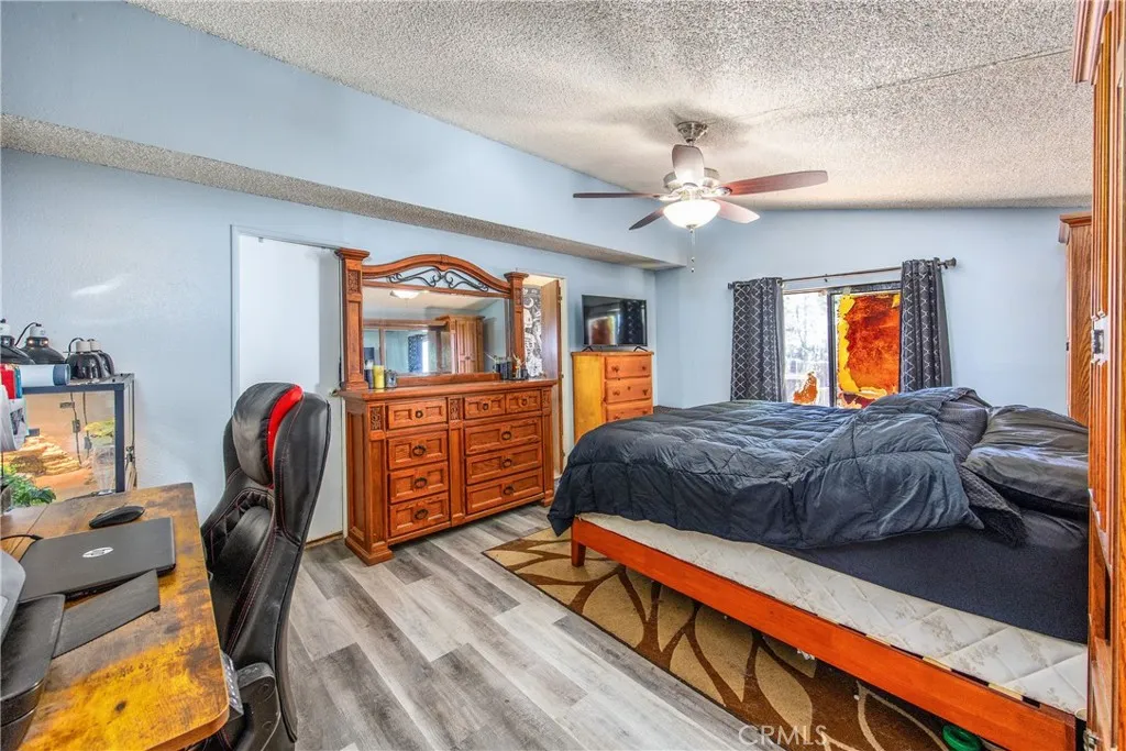 7717 Church Street, Unit 160 Highland, CA 92346 - Photo 23 of 37 a bedroom with a bed and dresser with mirror