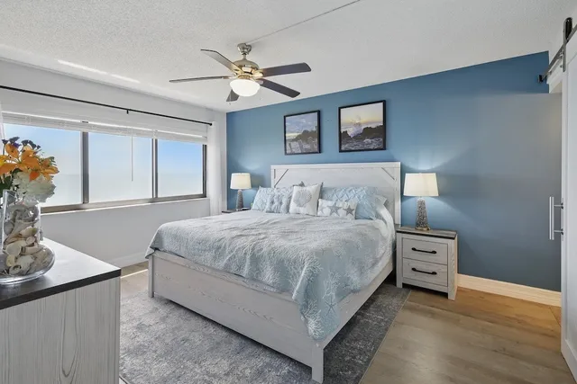 a bedroom with a bed and a lamp on the dresser