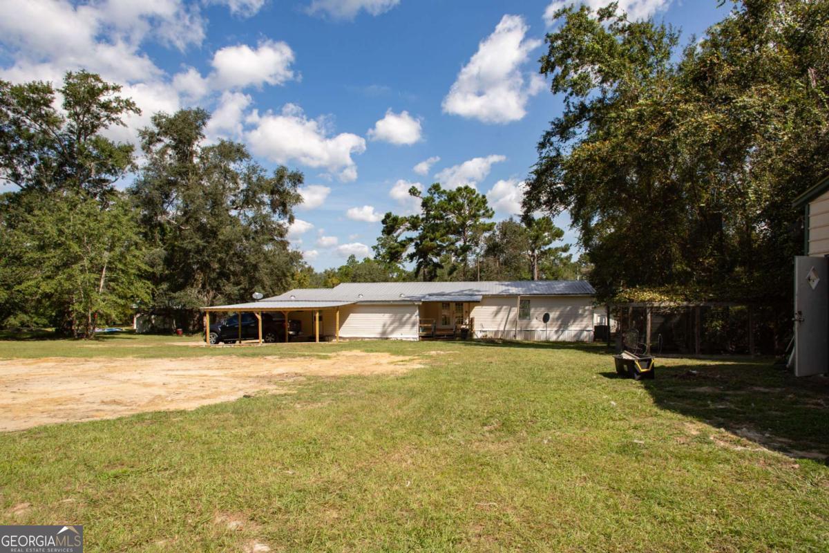 4535 Oak View Circle Waycross, GA 31503 - Photo 28 of 33 a view of a swimming pool with lawn chairs and plants