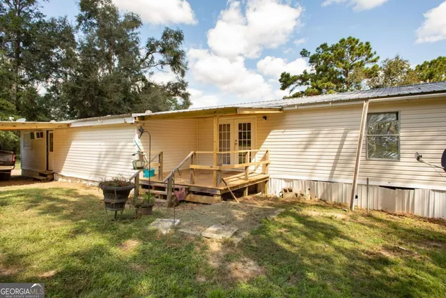 a backyard of a house with table and chairs