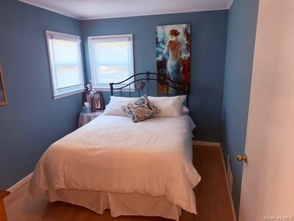 a bedroom with a bed and painting on the wall