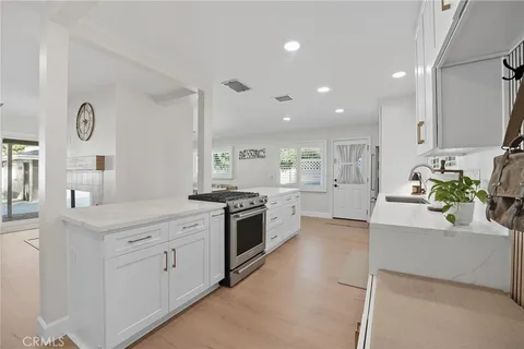 a large kitchen with stainless steel appliances granite countertop a lot of counter space and wooden floors