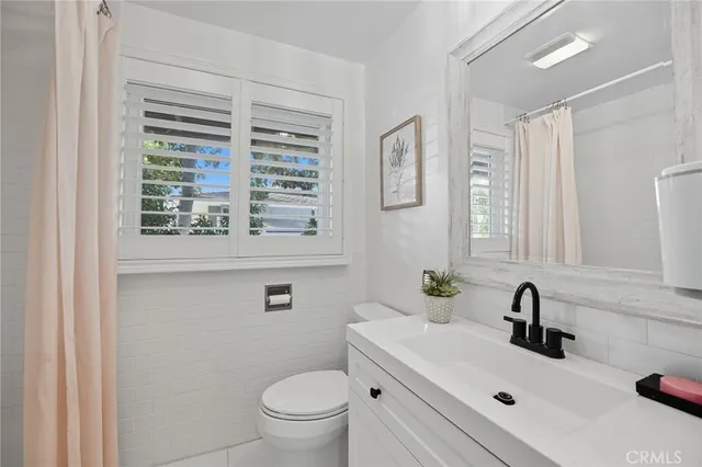 a bathroom with a sink a toilet and a window