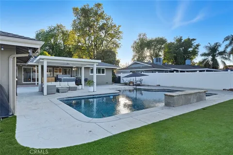a view of a white house with a swimming pool and a yard