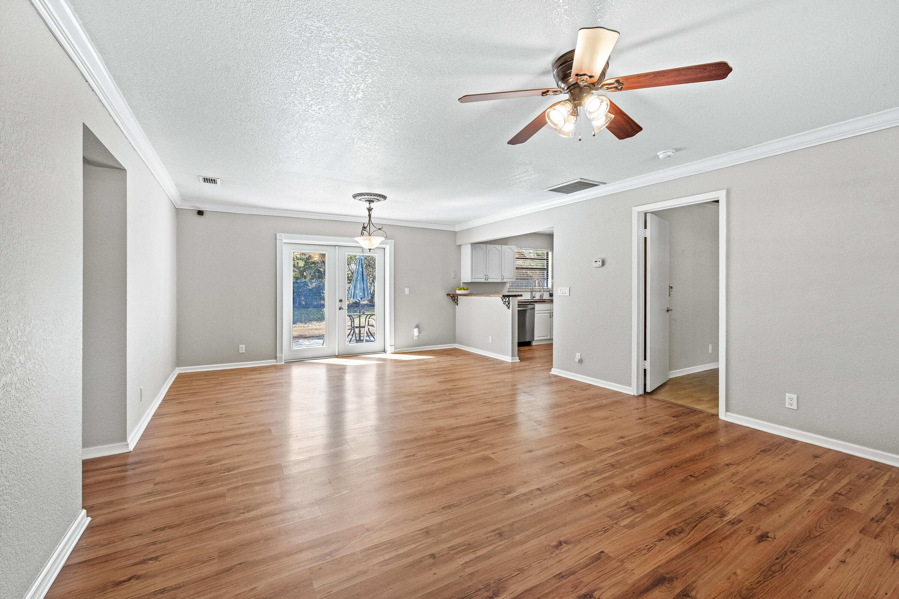 a view of empty room with wooden floor and fan