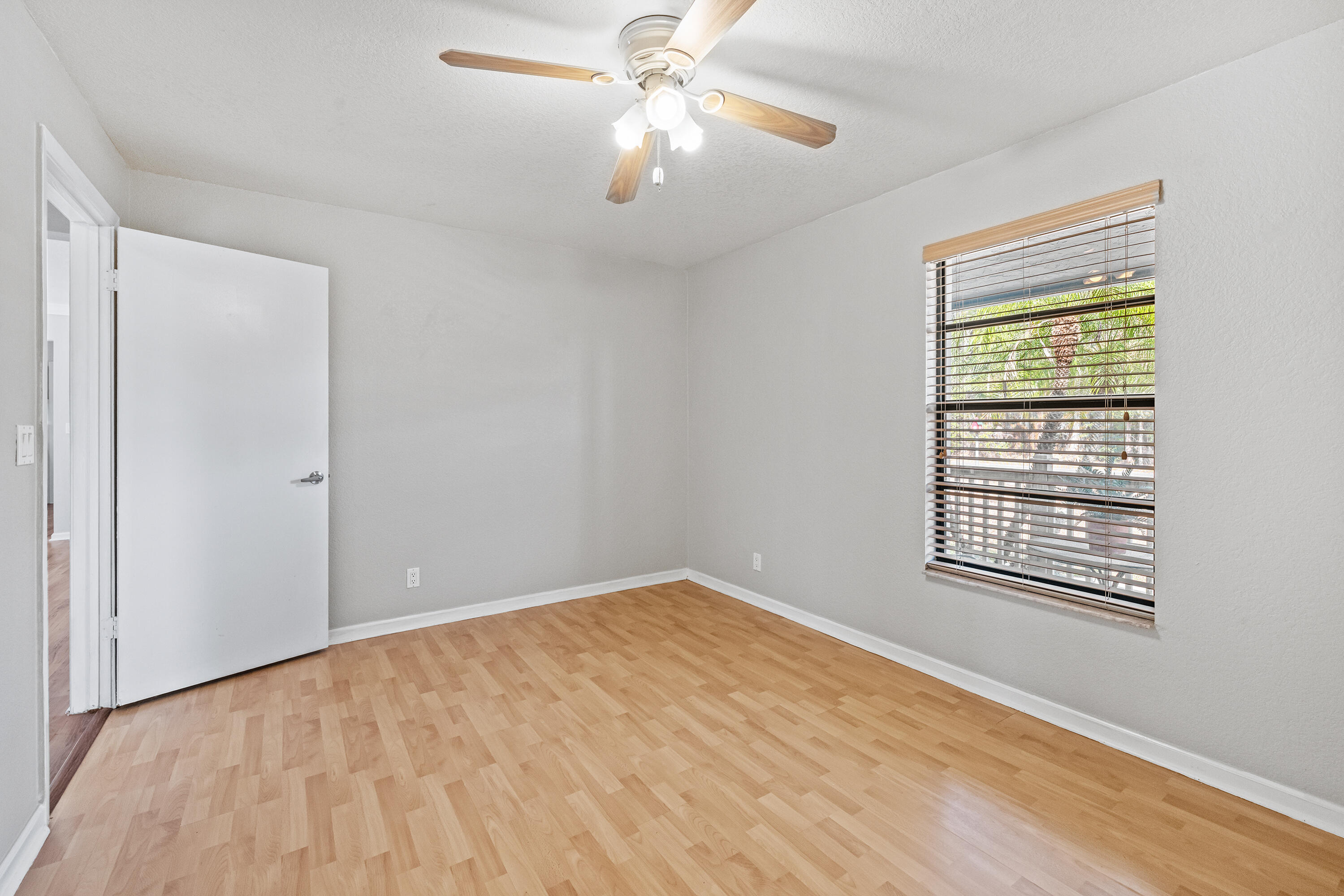 15400 76th Road North Loxahatchee, FL 33470 - Photo 17 of 39 a view of an empty room with chandelier fan and a window