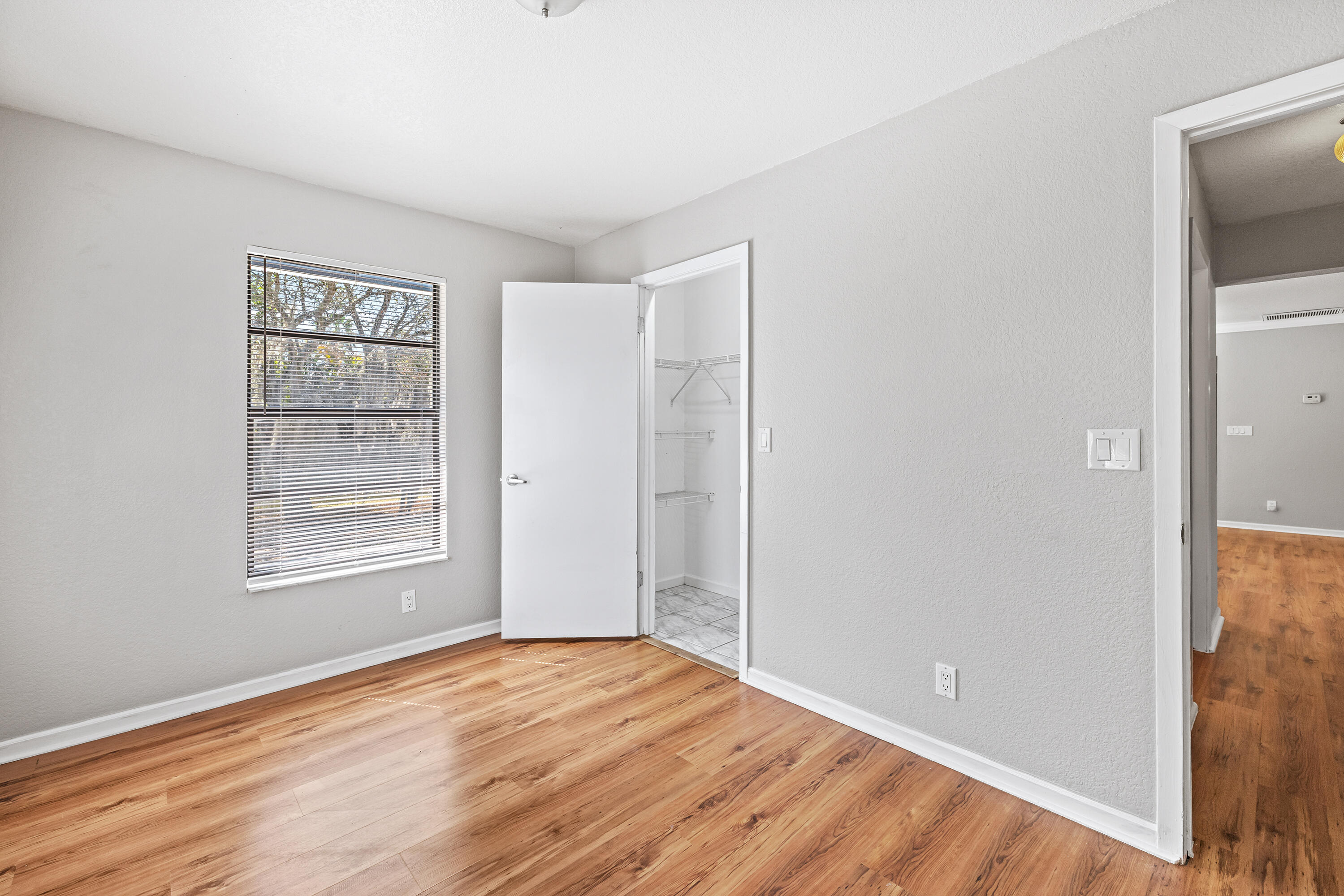 15400 76th Road North Loxahatchee, FL 33470 - Photo 22 of 39 a view of an empty room with wooden floor and a window
