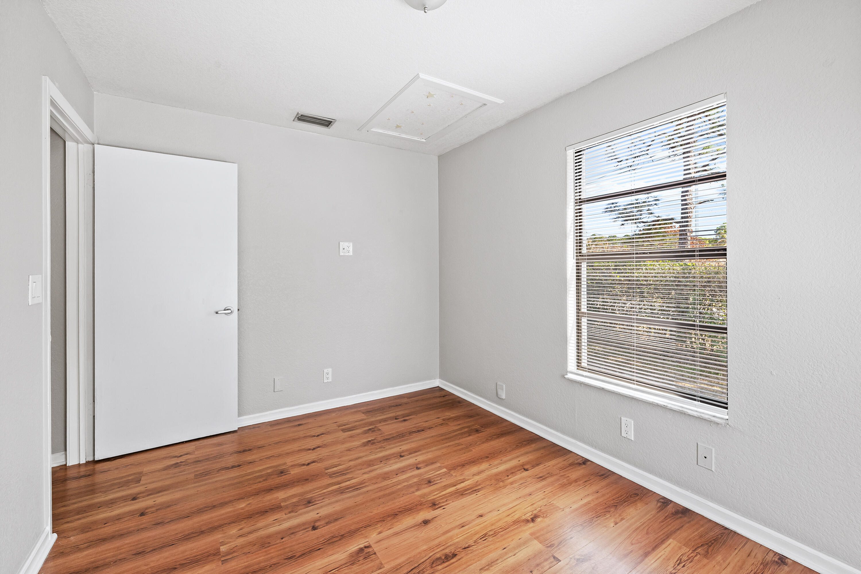 15400 76th Road North Loxahatchee, FL 33470 - Photo 23 of 39 a view of an empty room with wooden floor and a window