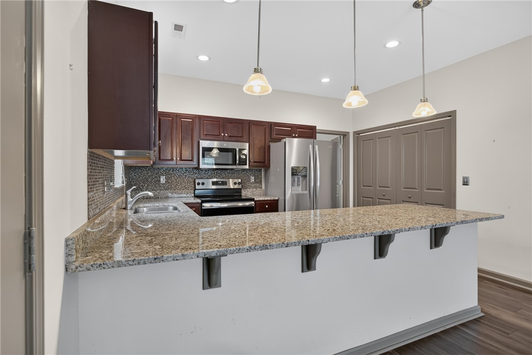 235 Pendleton Road, Unit K1 Clemson, SC 29631 - Photo 16 of 49 A contemporary kitchen features rich cabinetry, speckled granite countertops, and modern stainless steel appliances.