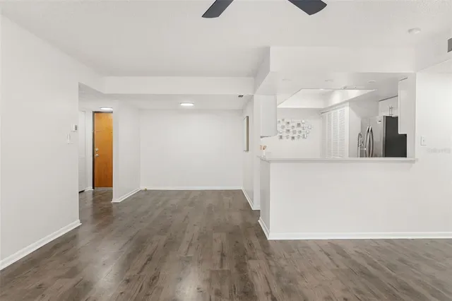a view of a big room with wooden floor and windows