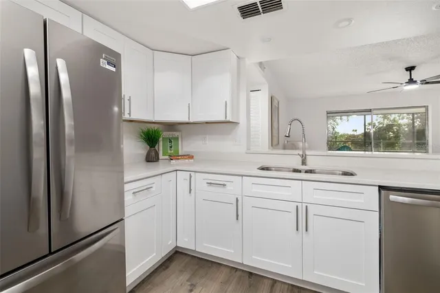 a kitchen with white cabinets and refrigerator
