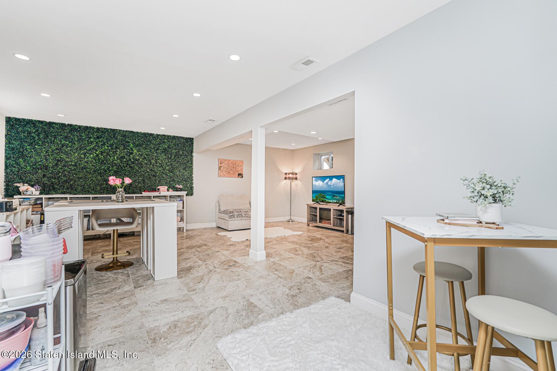 28 Drumgoole Road East Staten Island, NY 10312 - Photo 22 of 29 a living room with furniture a flat screen tv and a floor to ceiling window