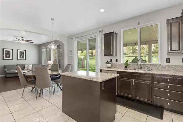 a dining hall with stainless steel appliances granite countertop a sink and a large window