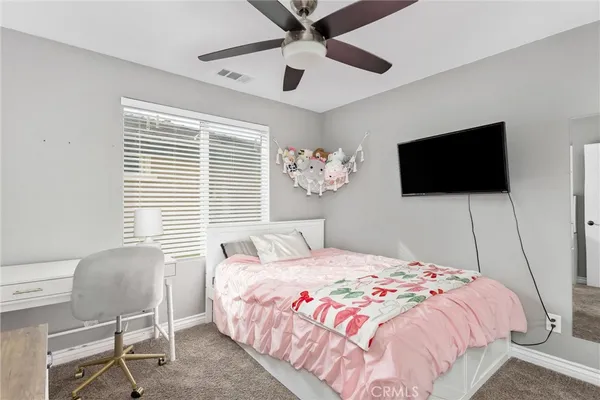 a bedroom with a bed tv and a window