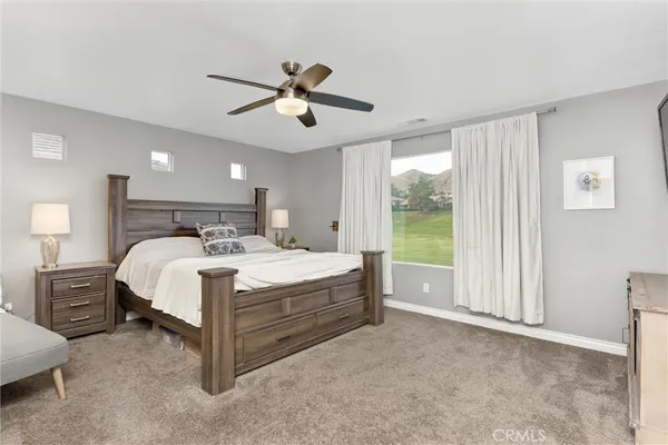 a bed room with a bed and a ceiling fan