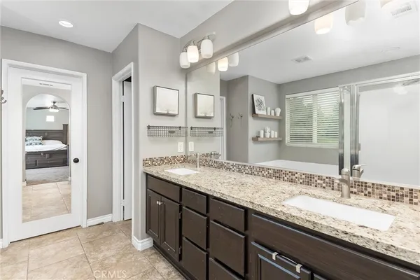 a bathroom with a granite countertop sink and a mirror