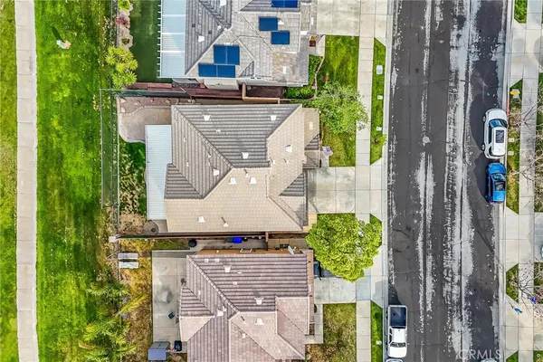 an aerial view of residential houses with outdoor space and trees