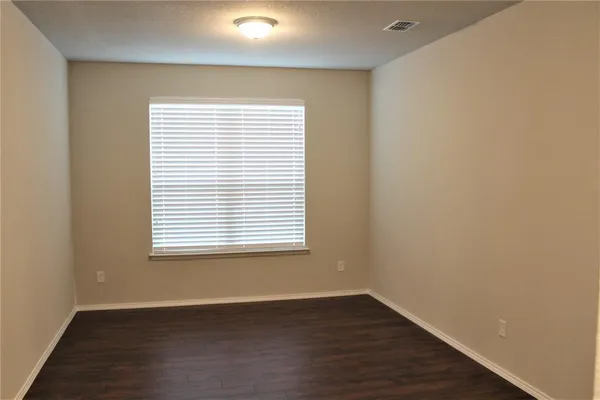 an empty room with wooden floor and a window