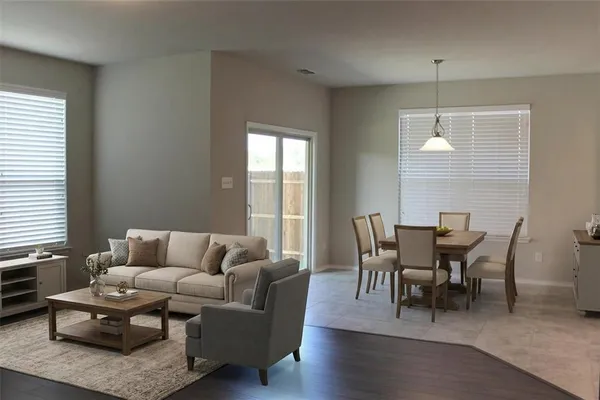a living room with furniture wooden floor and a window