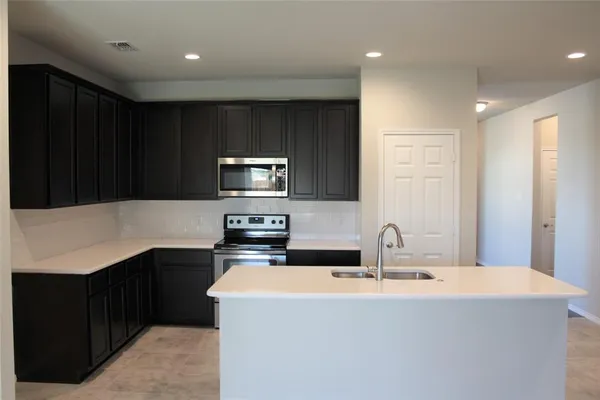a kitchen with a sink a microwave and cabinets