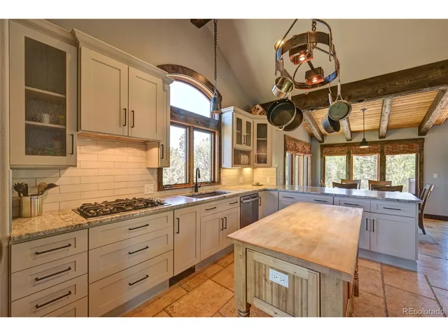 a kitchen with stainless steel appliances kitchen island granite countertop a stove a sink and a refrigerator