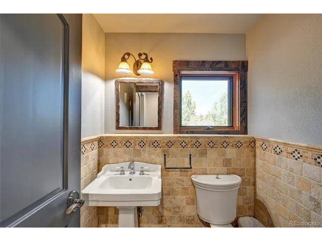 a bathroom with a sink vanity granite tub and a mirror
