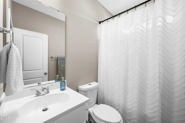 a bathroom with a white sink a toilet and a mirror