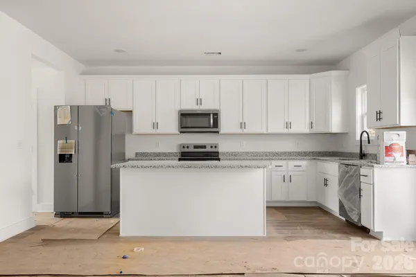 a kitchen with stainless steel appliances granite countertop a refrigerator stove top oven and sink