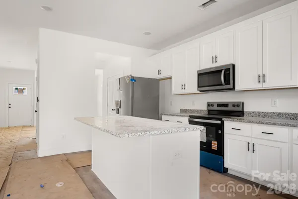 a kitchen with stainless steel appliances granite countertop a refrigerator stove a sink and dishwasher