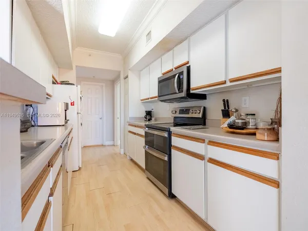 a kitchen with stainless steel appliances granite countertop a refrigerator sink and stove