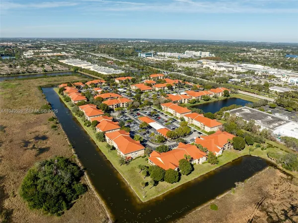 an aerial view of ocean and residential houses with outdoor space