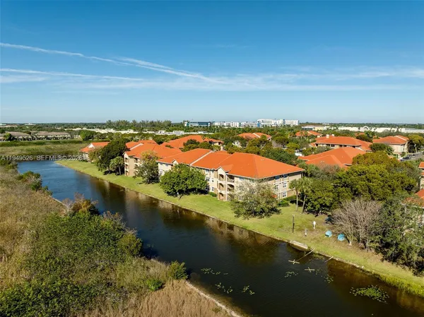 an aerial view of residential houses with outdoor space and lake view