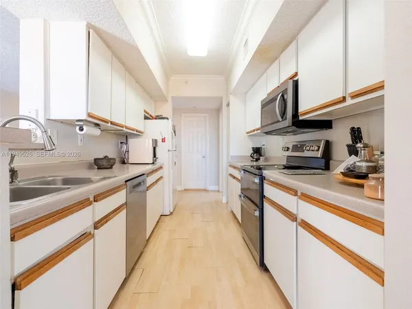 a large kitchen with stainless steel appliances granite countertop a lot of counter space and wooden floor