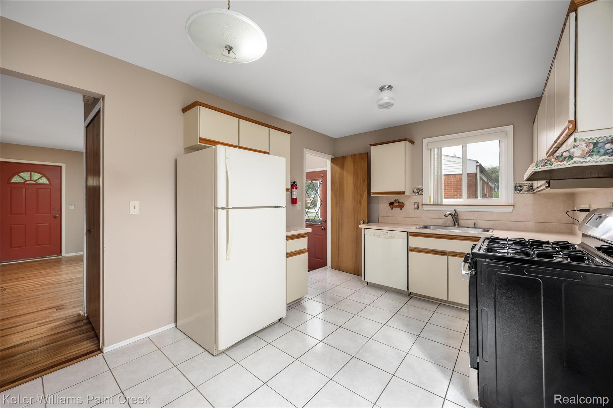 1766 Henry Ruff Road Garden City, MI 48135 - Photo 5 of 36 Kitchen featuring white tile flooring, ample cabinetry, a built-in sink, and a window