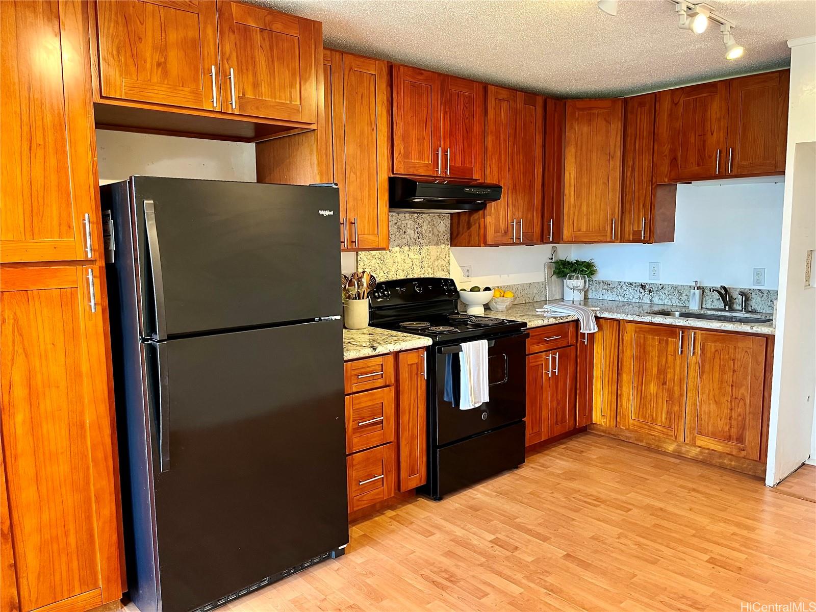 a kitchen with a sink refrigerator and cabinets